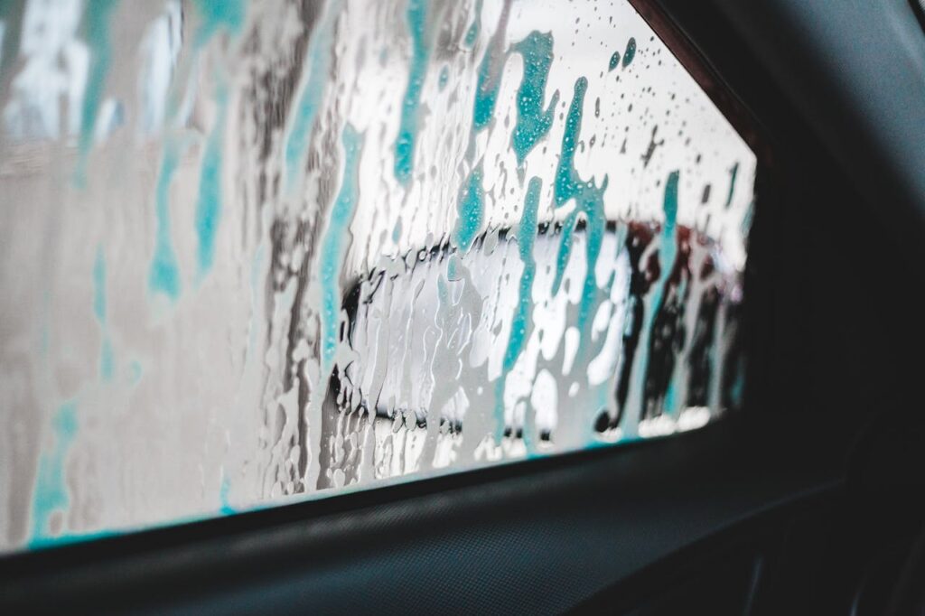 View from inside a car with soap suds on the window during a wash. Modern and clean.
